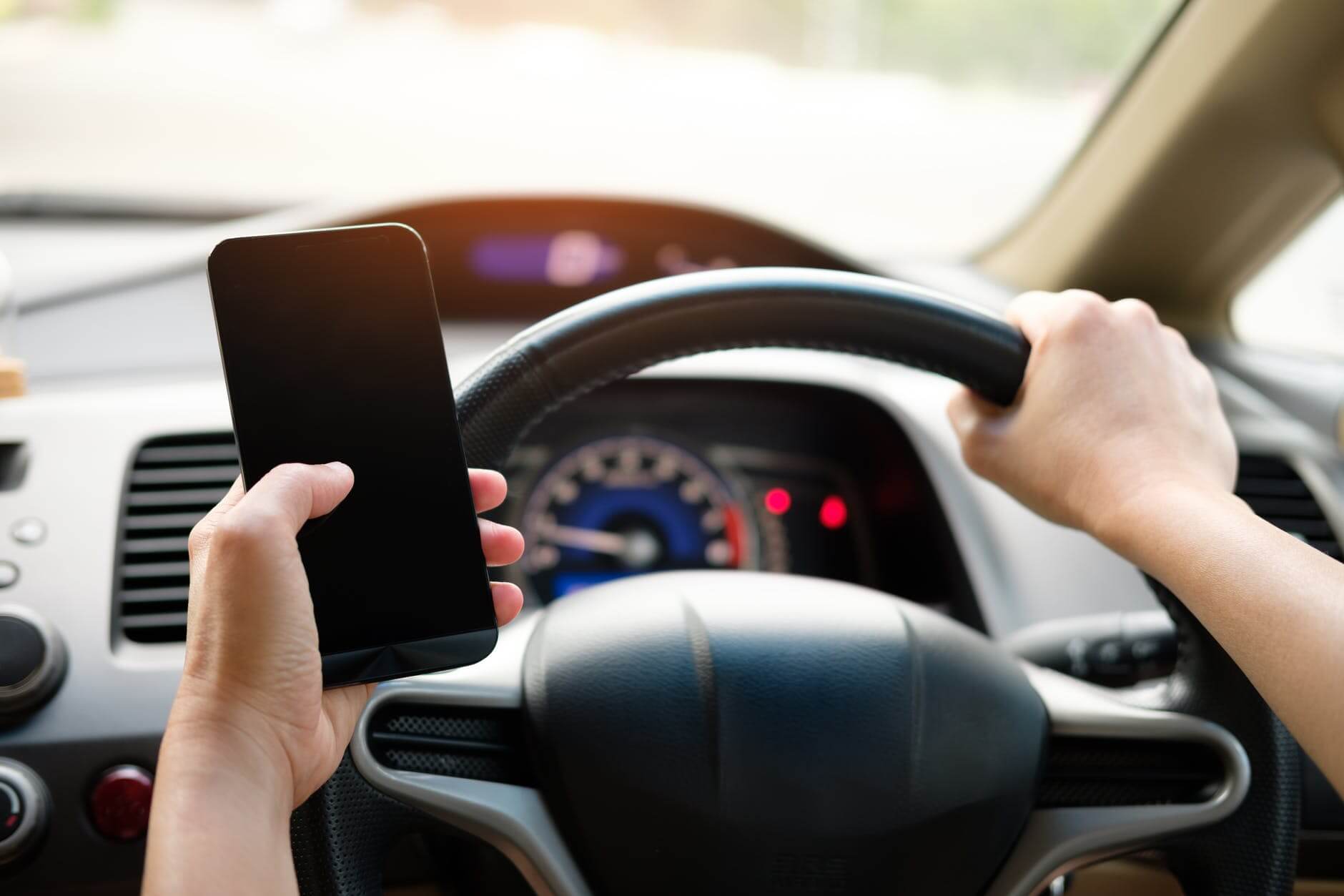 a driver holding smartphone inside the car