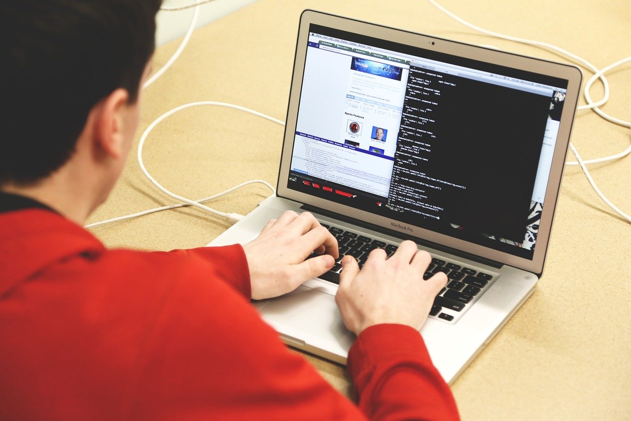 a man coding on his macbook from his home